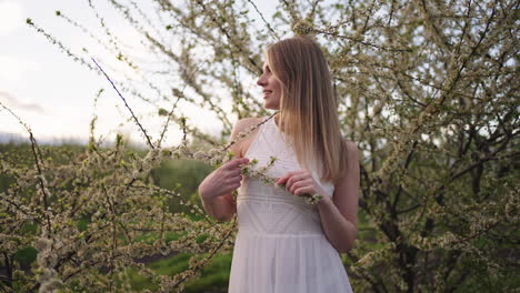 beautiful-blonde-woman-in-blooming-orchard-in-springtime-portrait-of-charming-lady-in-nature
